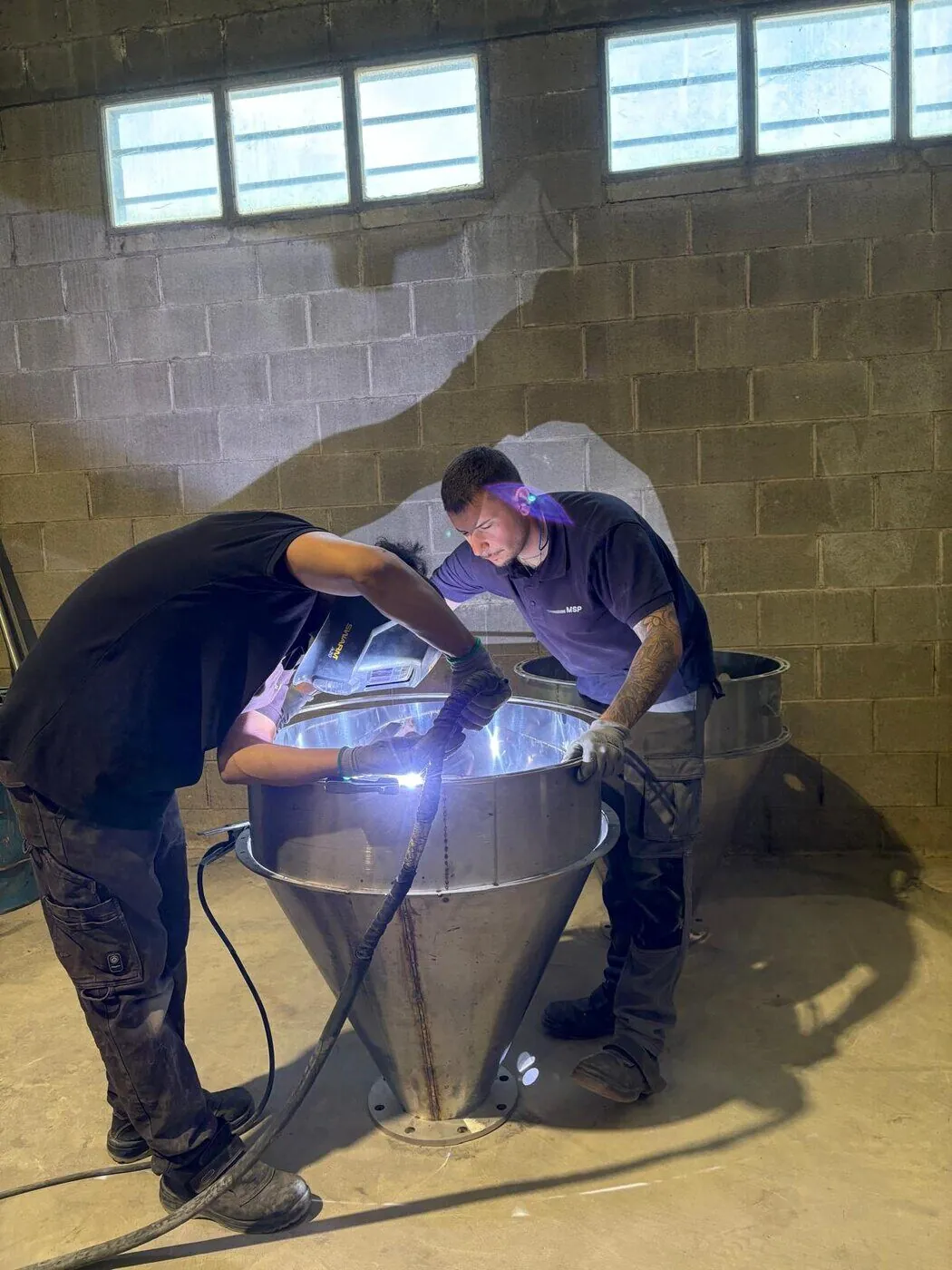 El equipo de MSP Soldaduras soldando un depósito cónico de acero inoxidable en el taller